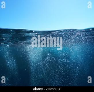 Bolle d'aria subacquea mare e cielo blu, vista split sopra e sotto superficie d'acqua, mare Mediterraneo Foto Stock