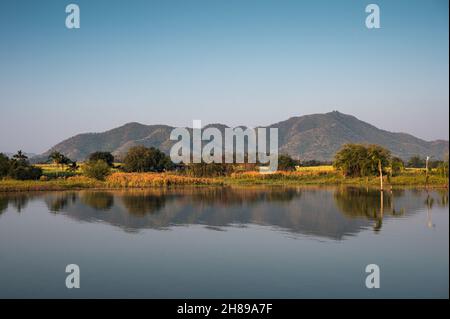Scenario di catena montuosa riflessa sul lago artificiale di Lam Thaphoen al mattino Foto Stock