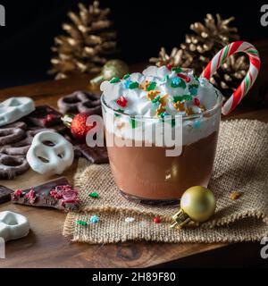 Vista ravvicinata di una tazza di cioccolata calda con panna a frusta e spolverini. Foto Stock