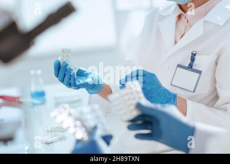 scienziati con campioni di nuovi farmaci seduti a un tavolo di laboratorio. Foto Stock