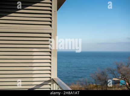 Aria condizionata grill sul balcone di un appartamento in un edificio residenziale a più piani che si affaccia sul mare. Foto Stock