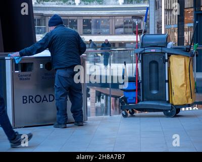 Pulitore per la lucidatura dei bidoni dei rifiuti a Broadgate, Londra. Broadgate è un'azienda di uffici e negozi di proprietà di British Land e GIC e gestita da Savills Foto Stock