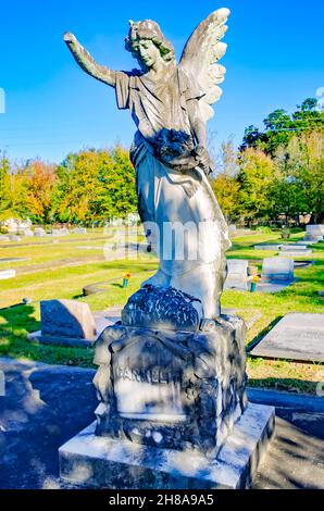 Un angelo cimitero si erge su una tomba al cimitero di Magnolia, 26 novembre 2021, a Mobile, Alabama. Il cimitero di 120 acri contiene più di 80,000 tombe. Foto Stock