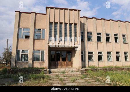 Abbandonato il vecchio edificio per uffici con finestre rotte Foto Stock