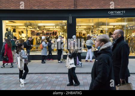 Londra, Regno Unito, 28 novembre 2021: I clienti di Natale tra le luci di Natale nel Covent Garden. Nonostante le preoccupazioni circa la nuova variante del coronavirus e l'imminente imposizione di regole più severe maschera in Inghilterra da martedì, il richiamo di Londra in una domenica pomeriggio soleggiato è stato attraente per gli acquirenti. Le code si sono formate con coloro che sperano di raccogliere un affare dalle offerte del Black Friday ancora in esecuzione. Anna Watson/Alamy Live News Foto Stock