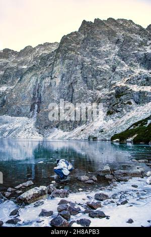 Lago nero (Czarny Staw pod Rusami) in inverno. Acque ghiacciate e solo turistico, montagne Tatra in Polonia. Acque verdi fredde. Foto Stock