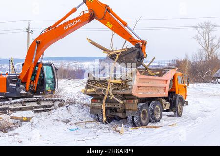 23 gennaio 2021, Kemerovo, Russia. Rimozione del sito e caricamento dei detriti con un escavatore nel cassone di un dumper Foto Stock