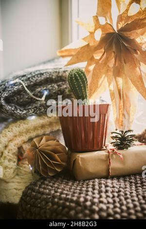 Stella di Natale scolpita a mano su un davanzale vicino ad un cactus in un POT. Natale senza spreco accogliente con decorazione riciclata. Messa a fuoco selettiva. Foto Stock