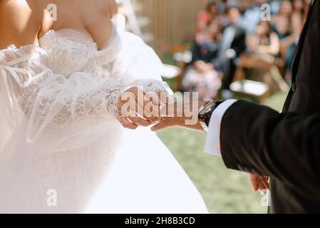 Primo piano di sposa mettendo l'anello di nozze sul dito delle spose Foto Stock