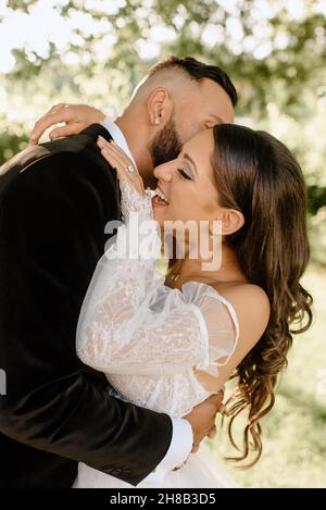 Sposi e sposi abbracciati nel parco Foto Stock