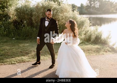 Sposi e sposi a piedi sul lago Foto Stock