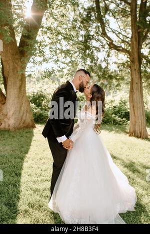 Sposa e lo sposo baciare in posizione di parcheggio Foto Stock