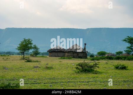 Masai villaggio vicino al cratere di Ngorongoro e MTO Wa Mbu. Piccole capanne Masai in savana africana, Tanzania Foto Stock