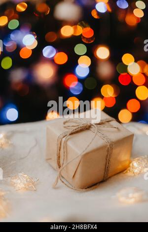 Piccolo regalo su maglione bianco, decorato albero di Natale su sfondo. Foto Stock