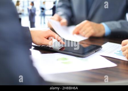 colleghi di lavoro che lavorano insieme e utilizzano un tablet digitale Foto Stock