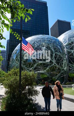 La gente cammina accanto al palazzo delle sfere amazzoniche con la bandiera degli Stati Uniti di fronte, Seattle, Washington Foto Stock