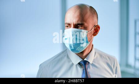 scienziato in una maschera protettiva sullo sfondo di un laboratorio medico. Foto Stock