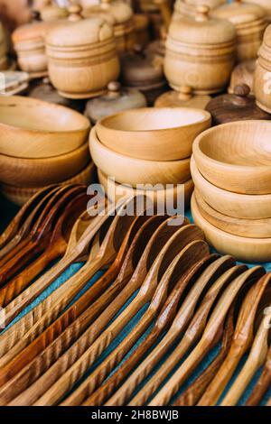 Stoviglie in legno fatte a mano sul banco. Cucchiai e piatti ecologici Foto Stock