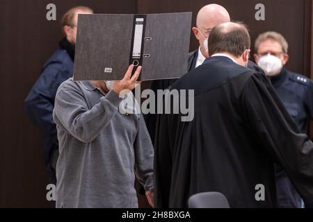 Norimberga, Germania. 29 novembre 2021. Un uomo (l) accusato di omicidio arriva all'inizio del processo in aula presso il Centro di Giustizia penale della Corte Regionale di Norimberga-Fürth. L'accusato è supposto per avere sparato la sua moglie separata in strada e un rivale presunto in un taxi. Credit: Daniel Karmann/dpa/Alamy Live News Foto Stock