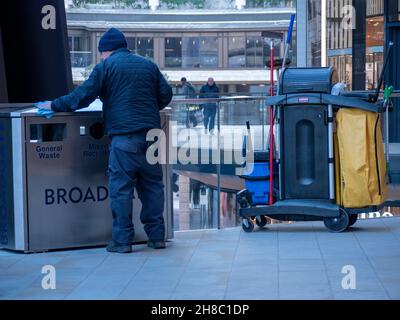 Pulitore per la lucidatura dei bidoni dei rifiuti a Broadgate, Londra. Broadgate è un'azienda di uffici e negozi di proprietà di British Land e GIC e gestita da Savills Foto Stock