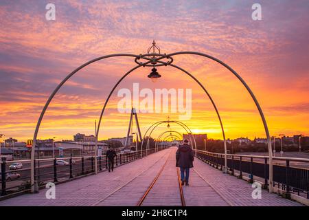 Southport, Merseyside. Meteo Regno Unito. 29 novembre 2021. Coperta di gelo invernale in legno e condizioni scivolose. Cielo rosso al mattino -2C all'alba mentre gli escursionisti del molo si prendono una passeggiata di mattina presto lungo il molo vittoriano di ferro del resort. Credit; MediaWorldImages/Alamy Live News Foto Stock