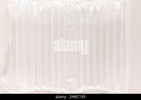 Involucro manicotto ammortizzante colonna d'aria per bottiglie. Pellicola a bolle d'aria per l'imballaggio. Sfondo astratto. Primo piano, inquinamento e concetto di fornitura di pacchetti fragili Foto Stock