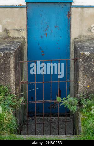vecchio cancello di ferro e porta di sicurezza blu, vecchio cancello arrugginito e porta d'ingresso dipinta di blu, porta posteriore o entrata tradizionale all'albergo vecchio stile. Foto Stock