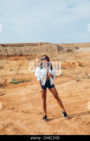 bella donna che cammina nel deserto di argilla Foto Stock