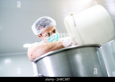 Primo piano ritratto di tecnico farmaceutico miscelazione di liquidi per la realizzazione di nuovi miture, aspetto concentrato. Laboratorio medico Foto Stock