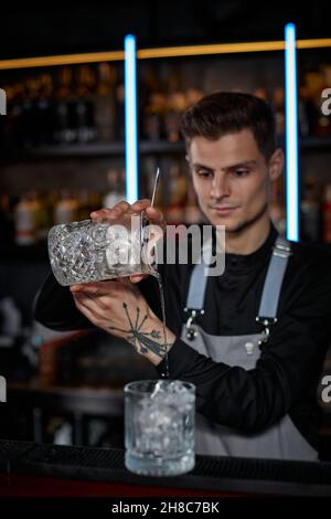 Il barista maschile professionista crea un cocktail alcolico Foto Stock