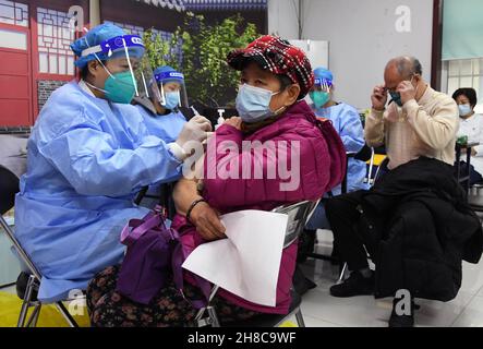 Pechino, Cina. 29 novembre 2021. Gli operatori sanitari somministrano booster di vaccini COVID-19 a residenti locali in un sito di vaccinazione temporanea a Pechino, capitale della Cina, 29 novembre 2021. Credit: Ren Chao/Xinhua/Alamy Live News Foto Stock