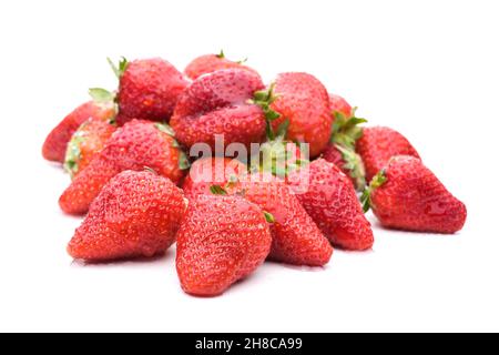 Molte fragole rosse in un mucchio isolato su sfondo bianco Foto Stock