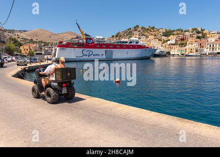 SYMI, GRECIA - 15 maggio 2018: La strada costiera nel porto di Symi Foto Stock