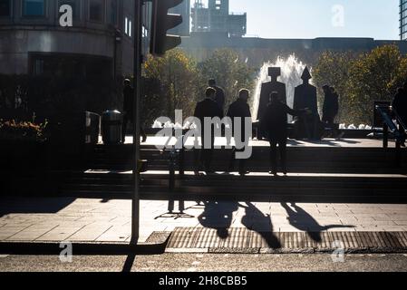 Persone a piedi silhouetted, Canary Wharf quartiere finanziario sull'Isola dei Dogs, Londra, Inghilterra, Regno Unito Foto Stock