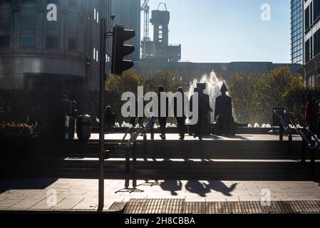 Persone a piedi silhouetted, Canary Wharf quartiere finanziario sull'Isola dei Dogs, Londra, Inghilterra, Regno Unito Foto Stock