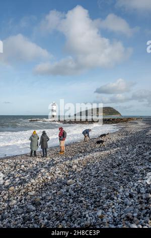 La famiglia può godersi una passeggiata sulla spiaggia di ciottoli a Penmon, Anglesey, Galles Foto Stock