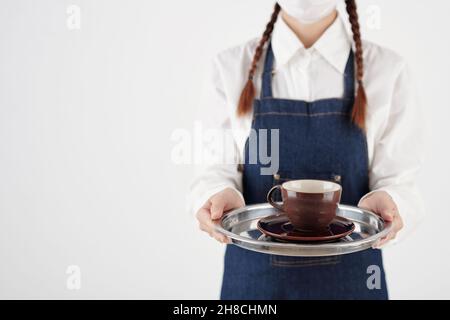 Immagine ritagliata del vassoio di contenimento della barista femminile con una tazza di caffè o tè Foto Stock