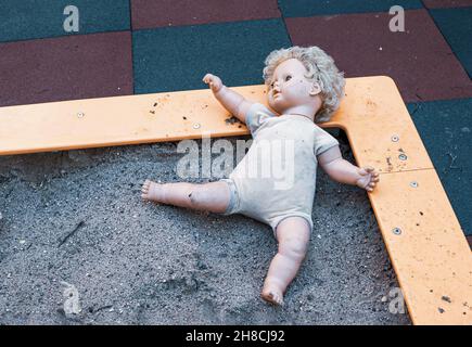 Vecchia bambola abbandonata non amata nel parco giochi Foto Stock