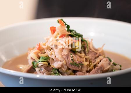 Primo piano: Menu tailandese di maiale bollito e fritto con pasta di gamberi in un recipiente bianco pronto per servire e mangiare. Foto Stock