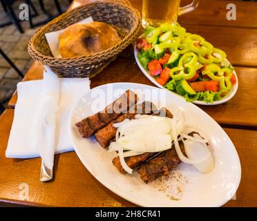 Qofte, le polpette grigliate, con pane, e insalata, Tirana, Albania Foto Stock