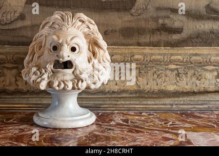 Primo piano su un'antica scultura in marmo che rappresenta un volto maschio brutto e arrabbiato Foto Stock