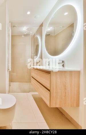 Immagini Stock - Spazio Bagno Beige Con Specchio Rotondo Sopra