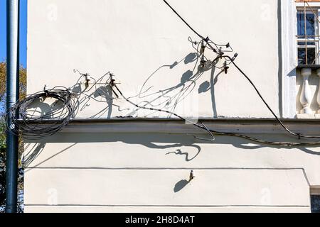Apparecchiature elettriche e cavi alta tensione linee sulla parete del vecchio edificio Foto Stock