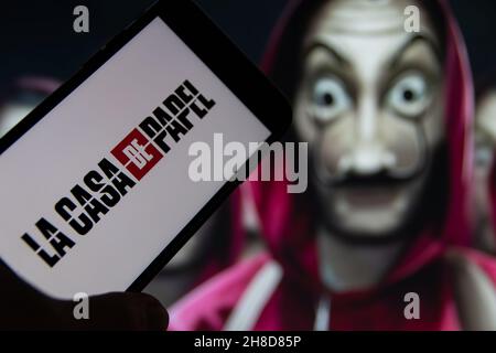 Rheinbach, Germania 15 ottobre 2021, il logo della serie Netflix 'la Casa De Papel' sul display di uno smartphone di fronte alla TV Foto Stock