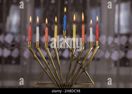 Menorah di festa ebraica con candele brucianti per Hanukkah su sfondo nero con candele colorate. Foto Stock