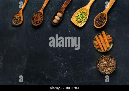 Selezione di spezie su fondo di cemento scuro. Cibo o concetto di cottura speziato, mangiare sano sfondo. Foto Stock