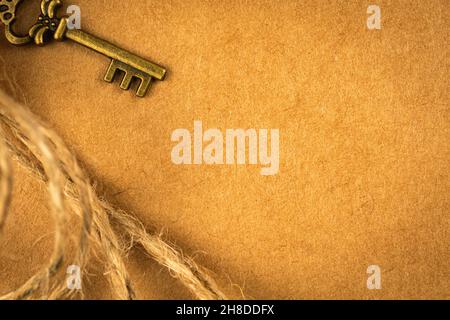 Carta cartografica del tesoro con chiave in bronzo, sfondo con texture grunge. Concetto di cartolina vintage, spazio copia e vista dall'alto Foto Stock