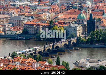 L'arco medievale in pietra Ponte Carlo (Karlův Most) sul fiume Moldava e i colorati edifici storici di Praga Foto Stock