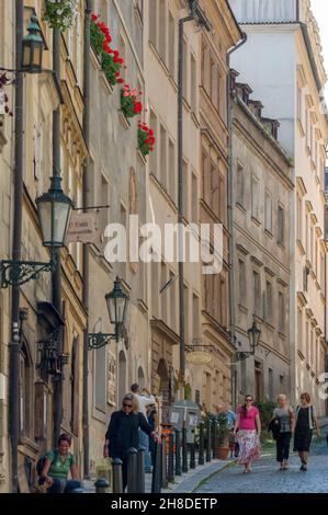 Le luminose finestre rosse aggiungono un tocco di colore agli alti edifici in pietra che costeggiano la stretta via Thunovská nella Malá Strana di Praga. Foto Stock