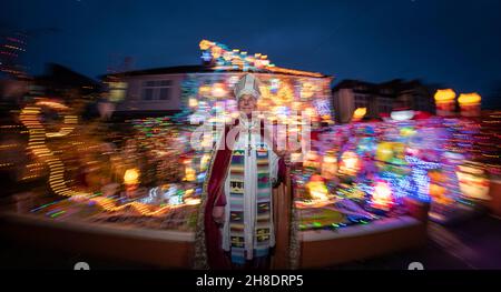 Londra, Regno Unito. 29 novembre 2021. Spettacolare mostra di luci della casa di Natale a Welling. Jonathan Blake (nella foto), Arcivescovo residente della Chiesa episcopale aperta, ha decorato la sua casa di famiglia ogni anno dal 2002. Per alcuni dei bambini locali, "la Casa di Natale" come la chiamano, è una parte vitale della loro esperienza di Natale. Bishop Blake utilizza il display annuale delle luci per aiutare a raccogliere fondi per fornire acqua pulita ai piccoli villaggi in Gambia. Credit: Guy Corbishley/Alamy Live News Foto Stock